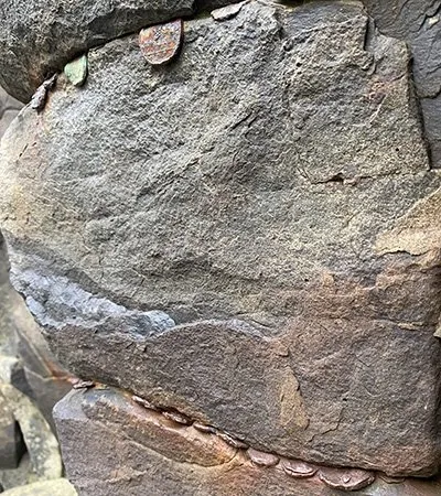 Coins pushed between the rocks for good luck